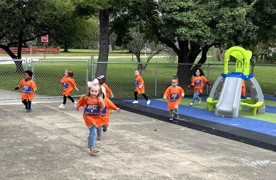 small children running around a playground