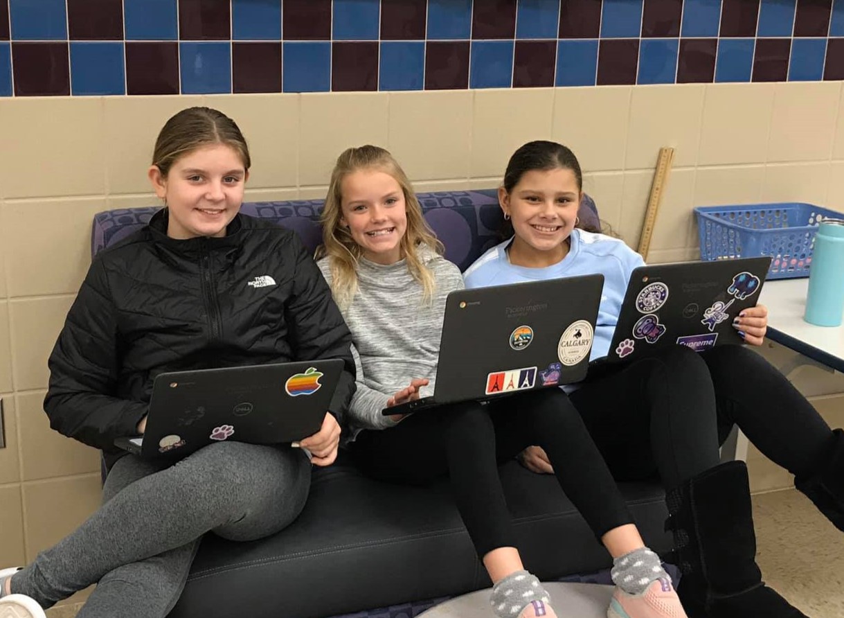 three Diley Middle School students smiling at the camera