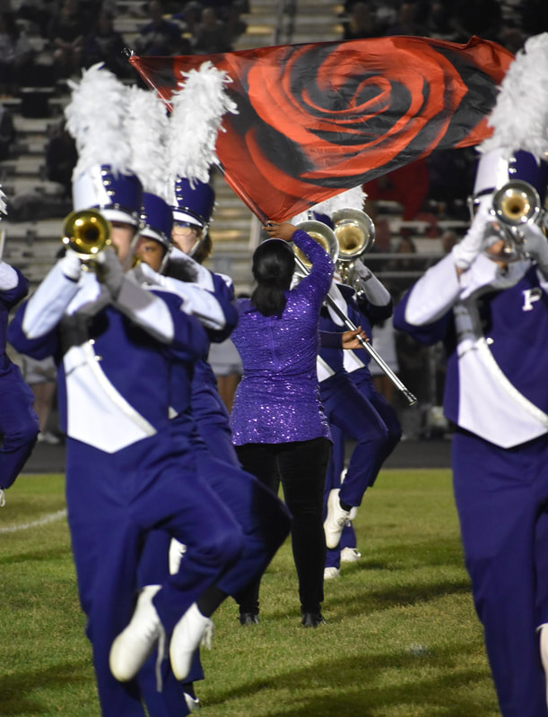A member of Pickerington High School Central's Color Guard twirls a flag amidst the Marching Tigers