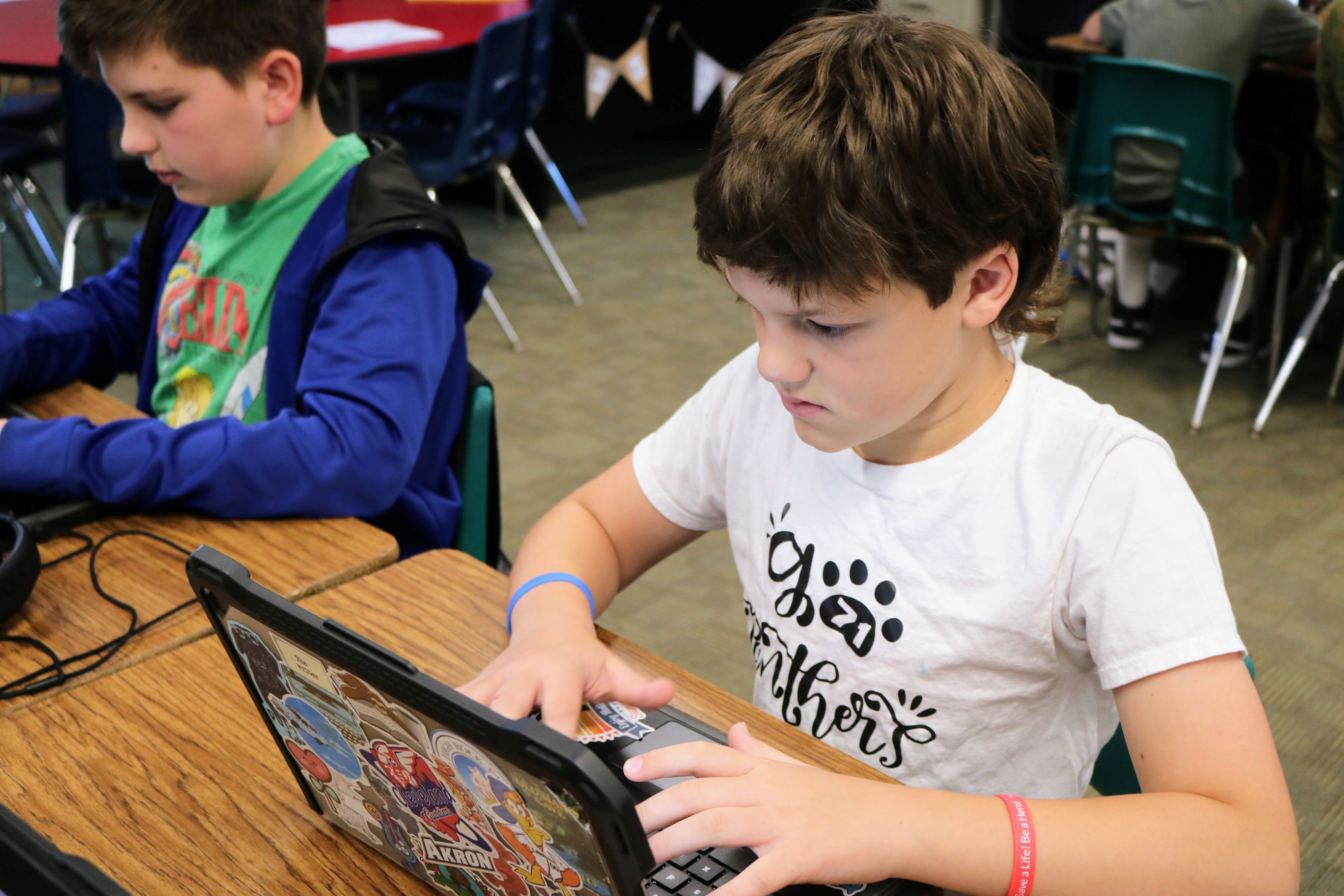 A students working on their Chromebook. They are frowning in concentration.