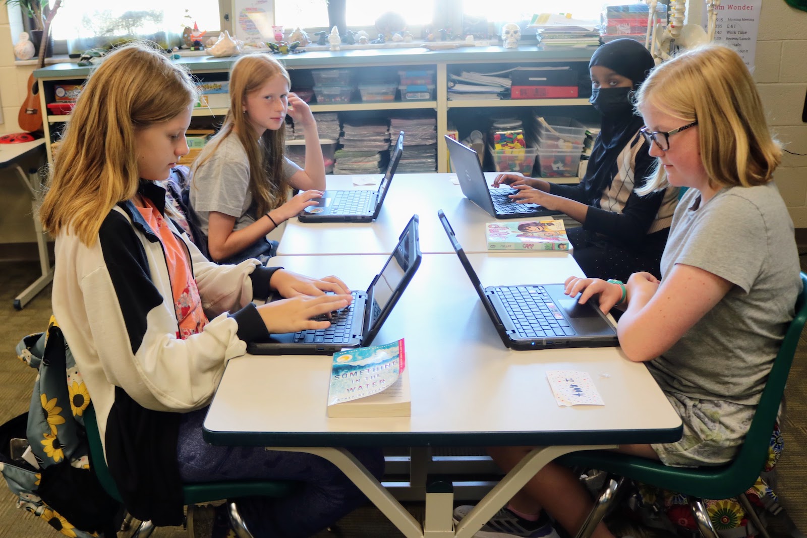 four girls working on their computers