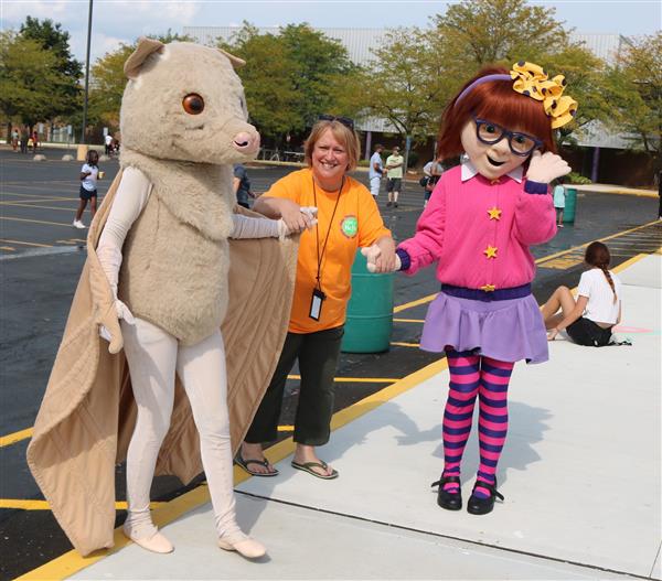 Storybook characters posing with an event attendee.