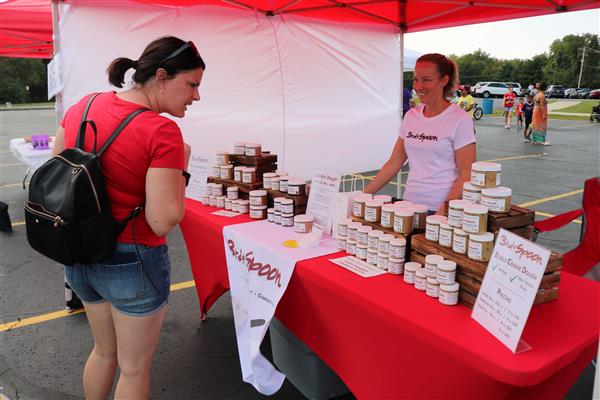 A person looks over the items at the 3rd & Spoon edible cookie dough vendor tent.