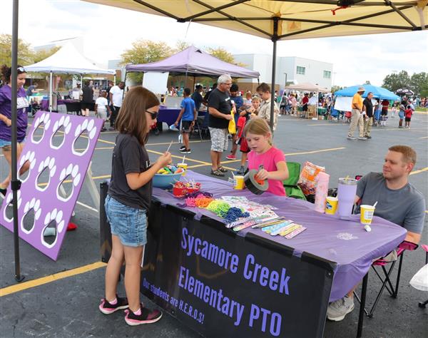 A young attendee checks out the Sycamore Creek PTO vendor booth.