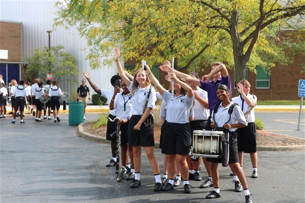 Members of the combined Marching Band wave to onlookers.